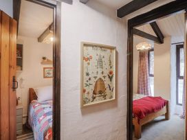 A bedroom with two beds and artwork framed at Honeypot Cottage Whitchurch Canonicorum