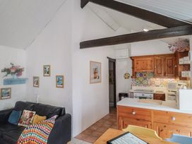 A kitchen with a sofa and wooden kitchen cabinets at Honeypot Cottage Whitchurch Canonicorum
