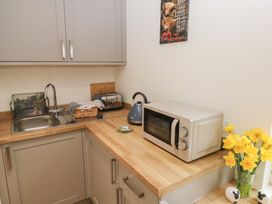A kitchen with a sink, kettle, toaster, and microwave at Heidiaway Lodge, Porth