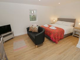 A bedroom with a bed and a sofa at Heidiaway Lodge in Porth