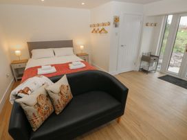 A bedroom with a bed and sofa at Heidiaway Lodge in Porth