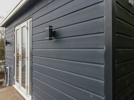 A side view of a building showing an entrance door and light fixtures at Heidiaway Lodge in Porth