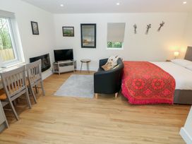 A studio layout with a bed, sofa, dining area and television at Heidiaway Lodge, Gilfach Goch
