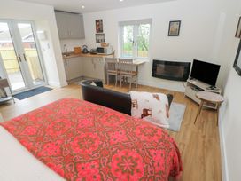 A living room with a kitchenette, dining table and sofa at Heidiaway Lodge in Gilfach Goch