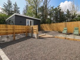 A garden with gravel area and wooden fence at Heidiaway Lodge in Gilfach Goch