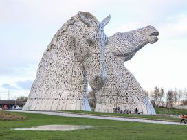 A sculpture of two horse heads in a park at Beechtree Timber Lodge 69B Denny