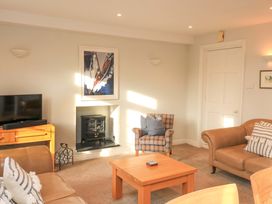 A living room with a television and a fireplace at Blackstone Cottage Salcombe
