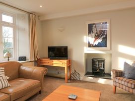 A living room with a television and sofa at Blackstone Cottage in Salcombe