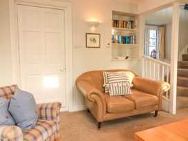 A living room with a sofa and bookshelf at Blackstone Cottage in Salcombe