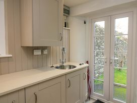 A kitchen with a sink and cabinet at Blackstone Cottage in Salcombe