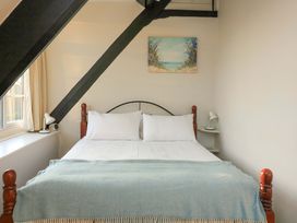A bedroom with a bed and side table at Blackstone Cottage Salcombe