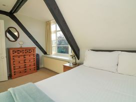 A bedroom with a bed and a chest of drawers at Blackstone Cottage in Salcombe