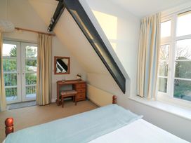 A bedroom with a bed and a table with a mirror at Blackstone Cottage in Salcombe