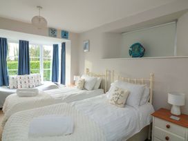 A bedroom with two beds and a window at Blackstone Cottage Salcombe