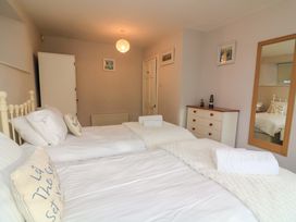 A bedroom with two beds and a dresser at Blackstone Cottage Salcombe