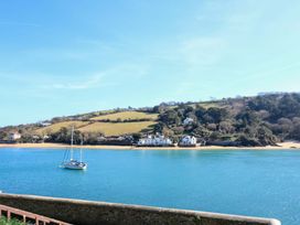A view of a bay with a sailboat and houses at Blackstone Cottage in Salcombe