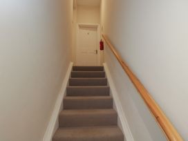 A staircase with a door and fire extinguisher at Flat 6