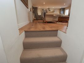 Stairs leading to a living room with furniture at Flat 6