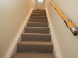 A staircase with carpet and a handrail at Flat 6