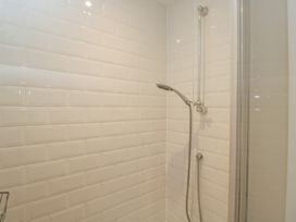 A shower area with tiles and shower fixtures at Flat 6 in 