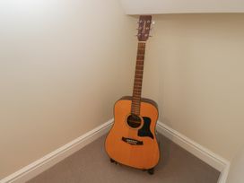 A guitar in a corner of a room at Flat 6 