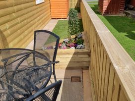 A seating area with a table and chairs beside a flower bed at 226 Third Avenue in Bridlington