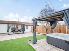 A garden with a hot tub and dining area at 6 Tegafan Abergele