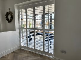 A dining room with window shutters at 6 Tegafan in Abergele