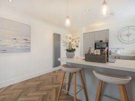 A kitchen with a kitchen island and bar stools at 6 Tegafan Abergele