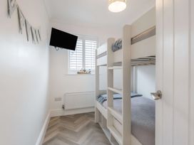 A bedroom with a bunk bed and television at 6 Tegafan Abergele