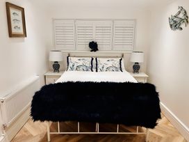 A bedroom with a bed, nightstands and lamps at 6 Tegafan in Abergele