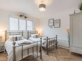 A bedroom with two beds and a wardrobe at 6 Tegafan in Abergele