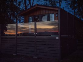 A building with glass railing and sliding door at Nethermill Lodges in Port Glasgow