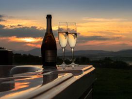 A bottle of prosecco and two glasses on a hot tub at Nethermill Lodges in Port Glasgow