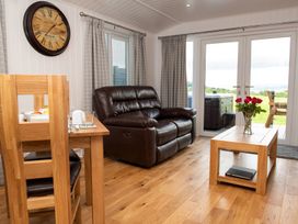 A living room with a sofa and a dining table at Nethermill Lodges in Port Glasgow