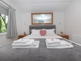 A bedroom with a bed and bedside table at Nethermill Lodges in Port Glasgow