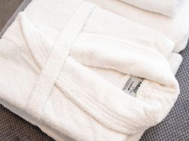 A folded bathrobe and towel at Nethermill Lodges in Port Glasgow