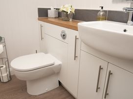 A bathroom with a toilet, sink, and cabinetry at Nethermill Lodges in Port Glasgow