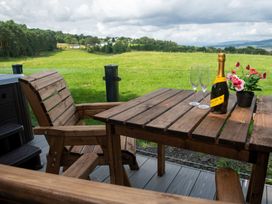 A table with chairs and champagne on a balcony at Nethermill Lodges in Port Glasgow