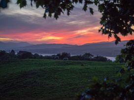 A sunset over hills with sheep grazing at Nethermill Lodges in Port Glasgow