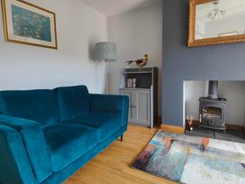 A living room with a blue sofa and bookshelf at 17 Castleview in Ballymena