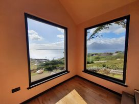 A room with large windows overlooking water at Cullinview in Isle of Skye
