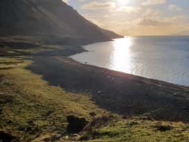 A sunset view of a pebble shoreline along the ocean at Cullinview in Isle of Skye