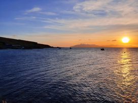 A view of the sea at sunset with boats and mountains at Cullinview in Isle of Skye