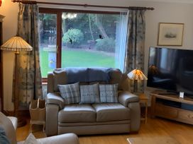 A living room with a sofa, cushions, and television at Fenton Drive in Wooler