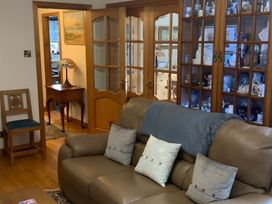 A living room with a sofa and a display cabinet at Fenton Drive in Wooler