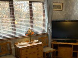 A living room with a television, table, and lamp at Fenton Drive in Wooler