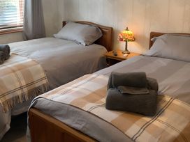 A bedroom with two beds and a bedside table at Fenton Drive in Wooler