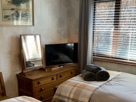 A bedroom with a television and a mirror at Fenton Drive Wooler