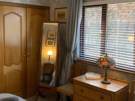 A bedroom with a wardrobe and a mirror at Fenton Drive in Wooler